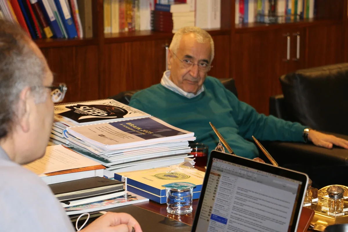 Doğan Cüceloğlu, kitaplarla dolu bir çalışma odasında otururken